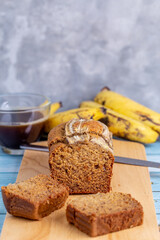 Delicious banana bread sliced on a wooden board with coffee cup on table for breakfast.