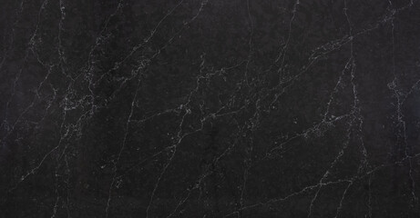 A dark marble looking quartz slab that contains a two-toned charcoal grey background with soft...