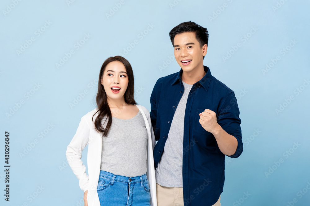 Wall mural Portrait of smiling cheerful Asian couple on isolated light blue studio background