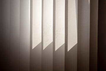 White vertical blinds illuminated by sunlight as an abstraction.