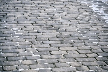 Close up cobblestone pavement in winter time. Textured, surface.