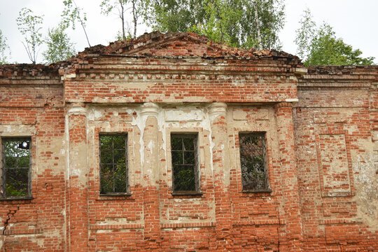 Old ancient abandoned red brick ruins overgrown by plants