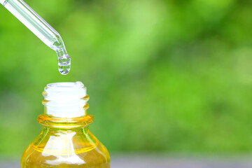 hands of a beautiful woman Dropping serum collagen moisturizer of face into clear yellow bottle soft light background. Protector skin Treatment facial essence oil, Vitamin C. Beauty and spa Concept