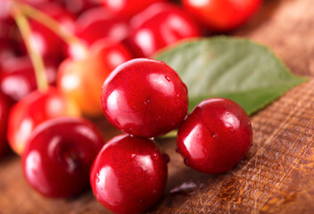 Cherries on wooden table with water drops