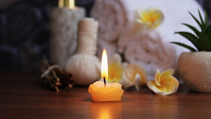 Obraz na płótnie Canvas Candle light of Spa accessories,Beautiful composition of spa , spa relax concept, herbs for massage, beautiful sap set on wood table,Dark tone