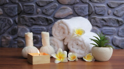 Obraz na płótnie Canvas Spa accessories,Beautiful composition of spa , spa relax concept, herbs for massage, beautiful sap set on wood table,Fragrant plumeria flower.