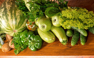 Useful green vegetables on a wooden background.