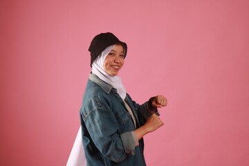 Fashion portrait of young beautiful asian muslim woman with wearing hijab isolated on pink background