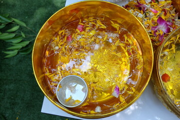 A bowl filled with clean water decorated with flower petals for bathing the Buddha image on the Songkran Day of the Thai New Year.