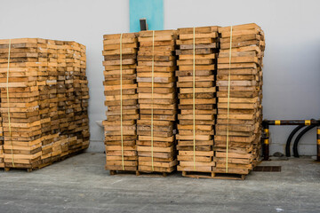 Wooden display crates stacked beside building.