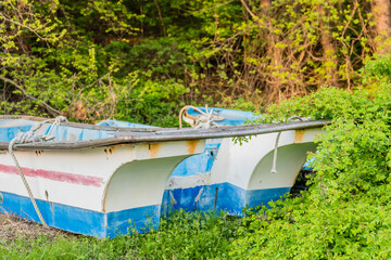 Fototapeta na wymiar Fishing boats on grassy mound beside row of tress