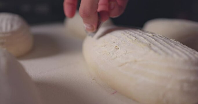 Baker Making Patterns On Raw Bread Using A Knife, slow motion 4k video 