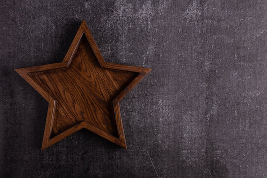 A large wooden star tray lies on a dark background.