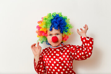 Hilarious five-year-old boy dances in clown costume and wig on white background