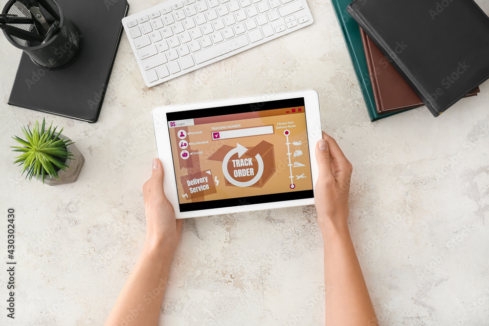 Poster woman using tablet computer with open page of delivery service application at table