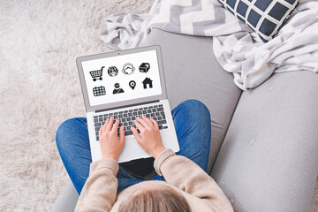 Woman using laptop with open page of delivery service application at home