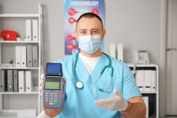 Doctor with payment terminal in clinic
