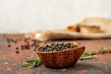 Bowl with peppercorns on grunge background