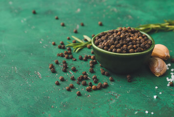 Bowl with peppercorns on color background