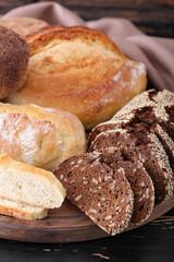 Board with fresh bread on wooden background, closeup