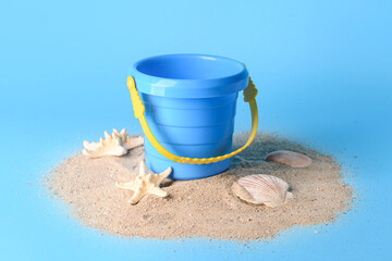 Fototapeta na wymiar Toy bucket for children with sand on color background