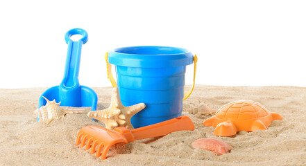 Fototapeta na wymiar Set of beach toys for children on sand against white background