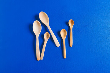 Wooden spoons on color background