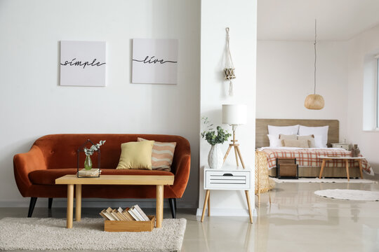 Stylish interior of living room with comfortable sofa and table