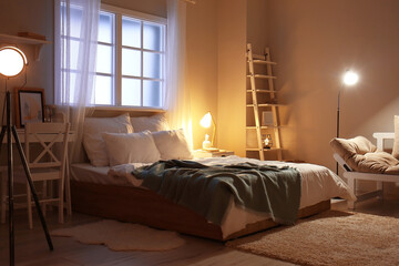 Obraz premium Stylish interior of bedroom late in evening