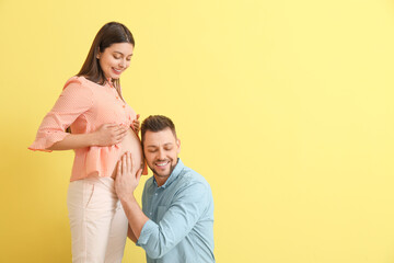 Fototapeta premium Beautiful pregnant couple on color background