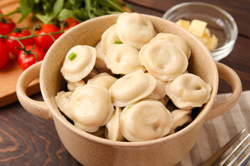 Bowl with tasty dumplings on wooden background