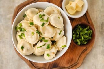Bowl with tasty dumplings on grunge background