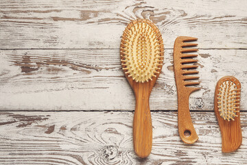 Hair comb and brushes on white wooden background - obrazy, fototapety, plakaty