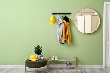 Stylish interior of hall with hanging clothes on wall