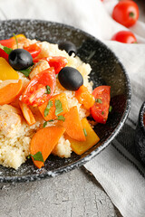 Plate with couscous and vegetables on grunge background