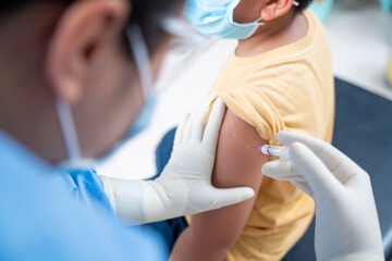 Close up Doctor making a vaccination in the shoulder of patient boy or child person, coronavirus,covid-19 vaccine disease preparing for human clinical trials vaccination shot, Injection on Arm