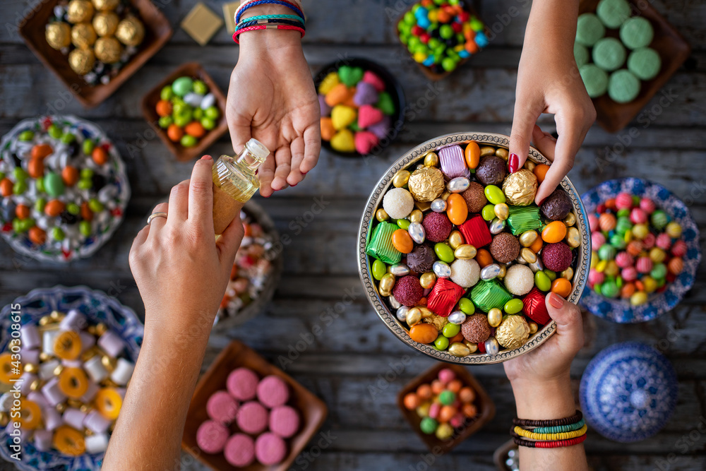 Wall mural Bowl of candies and chocolate at the hands of two women. Kız isteme ve şeker bayramı ikramı