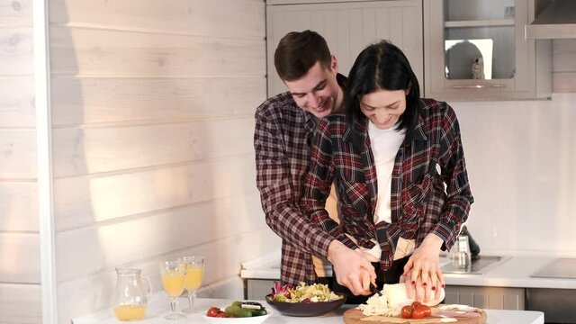 Young married couple cooking together at home