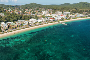 Aerial view of Shoal Bay foreshore, wharf and town, and beautilful aqua waters