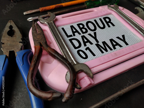 May 1st , Labour day poster with tools on Black background , text written in center.