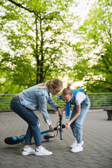 Obraz premium Mother helps her daughter after falling accident e-scooter