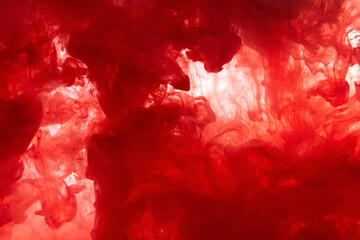 Abstract background picture with red paint dissolving in water