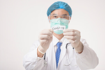 Doctor is holding Covid-19 card on white background