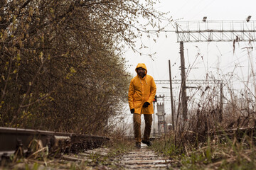 Fototapeta na wymiar Yellow cloak, forest. A man in a yellow raincoat, cold and wet weather.