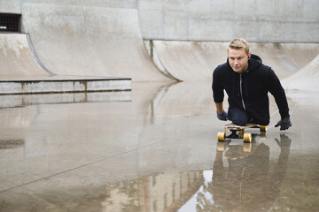 Young handicapped guy with a longboard in a skatepark