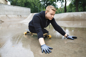 Young handicapped guy with a longboard in a skatepark