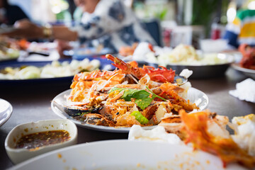 Dirty waste food and used napkin on plate after eating seafood party in the restaurant.