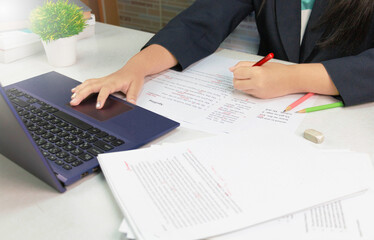 hand holding red pen over proofreading paper