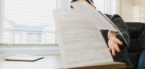 Male business director throwing documents at office.