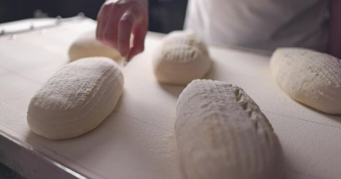Baker Making Patterns On Raw Bread Using A Knife, slow motion 4k video 